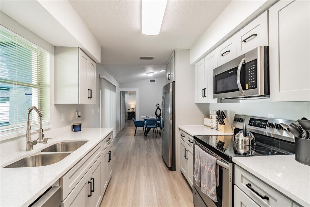 14003 Ridgedale Way Tampa, FL 33625 - Photo 20 of 28 a kitchen with stainless steel appliances a sink stove top oven and cabinets