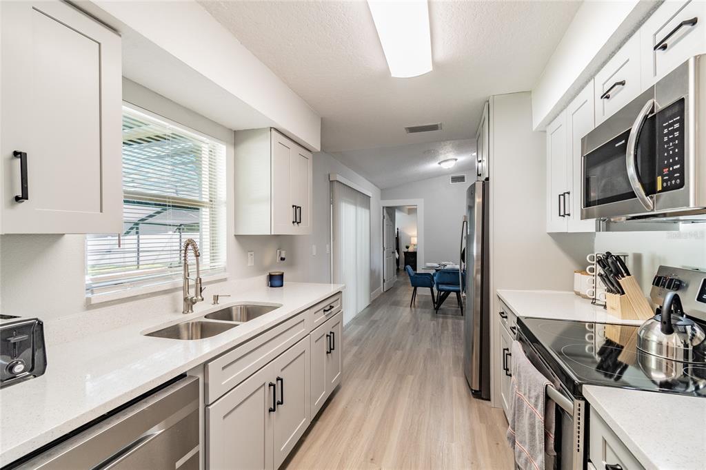 14003 Ridgedale Way Tampa, FL 33625 - Photo 21 of 28 a kitchen with stainless steel appliances a sink stove and cabinets