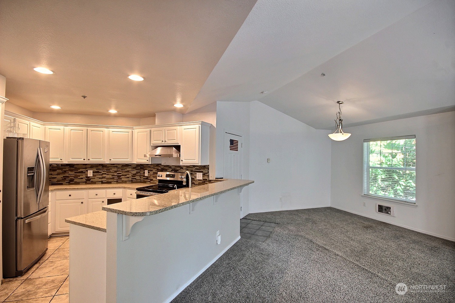 1826 Kennedy Place, Unit D7 DuPont, WA 98327 - Photo 2 of 19 a kitchen with stainless steel appliances kitchen island granite countertop a stove and a refrigerator