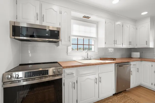 a kitchen with appliances a sink and cabinets