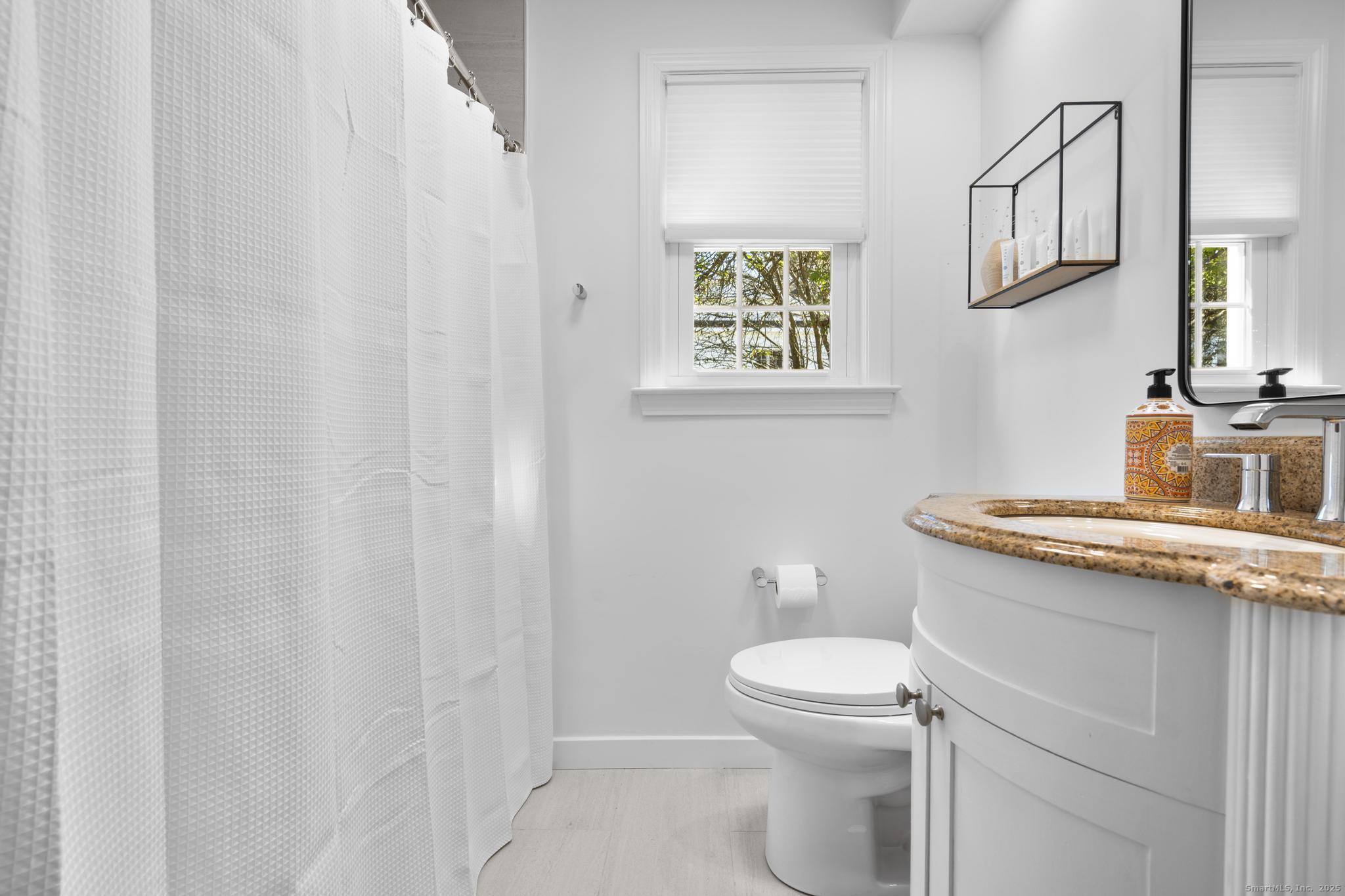 27 Reef Court Fairfield, CT 06824 - Photo 22 of 23 a bathroom with a granite countertop toilet sink and mirror