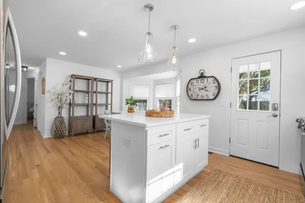 a large white kitchen with wooden floor