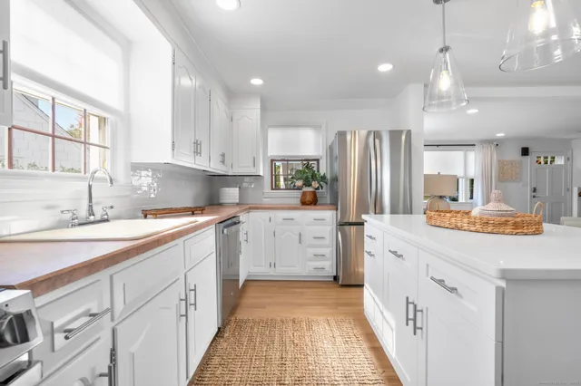 a kitchen with white cabinets sink and stainless steel appliances