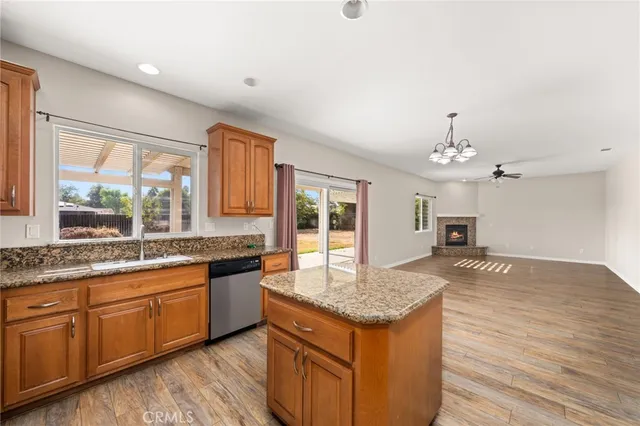 a kitchen with granite countertop kitchen island wooden floors and stainless steel appliances