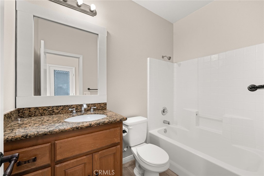 15868 Shorb Street Riverside, CA 92508 - Photo 6 of 15 a bathroom with a granite countertop sink toilet mirror and bathtub