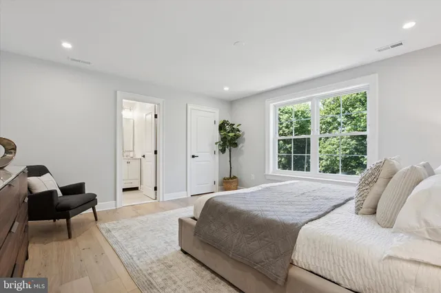 a spacious bedroom with a bed a couch and a window