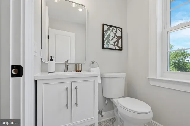 a bathroom with a toilet a sink and a window