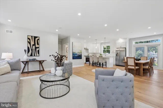 a living room with furniture a table and kitchen view
