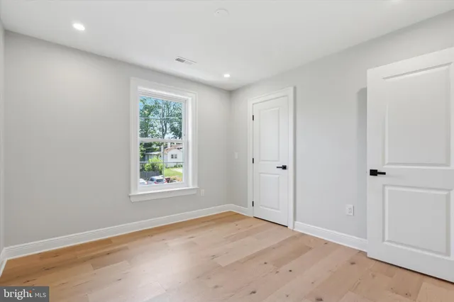 an empty room with wooden floor and window