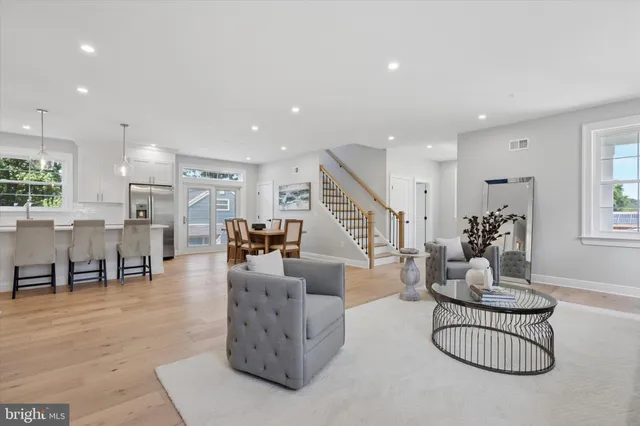 a living room with furniture and a dining table with kitchen view