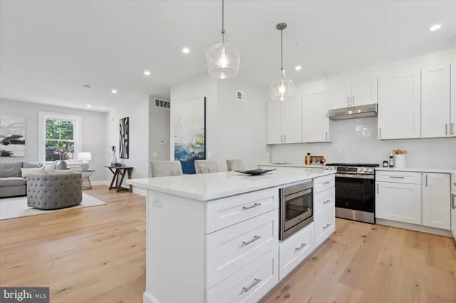 a kitchen with a sink stove and wooden floor