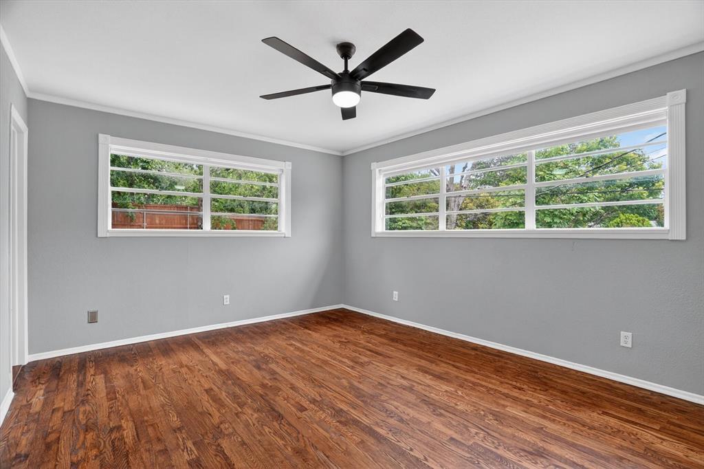 6609 Genoa Road Fort Worth, TX 76116 - Photo 20 of 40 Spacious room featuring wood-finish flooring, light gray walls, white trim, and a black ceiling fan with integrated lighting