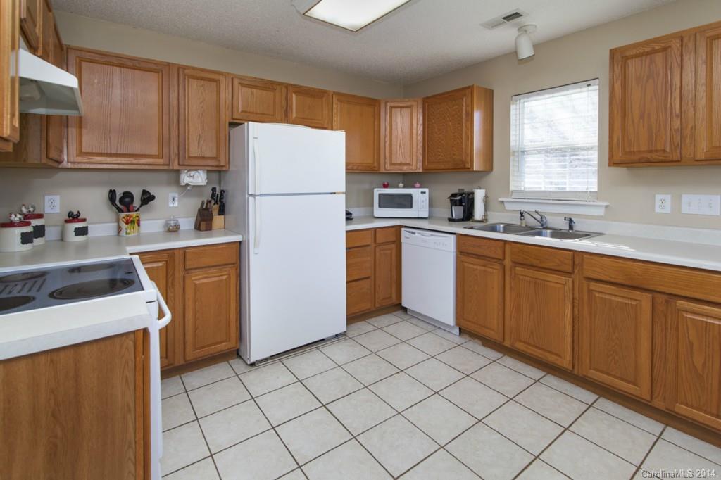 146 State Park Road Troutman, NC 28166 - Photo 6 of 18 a kitchen with a sink a refrigerator and cabinets