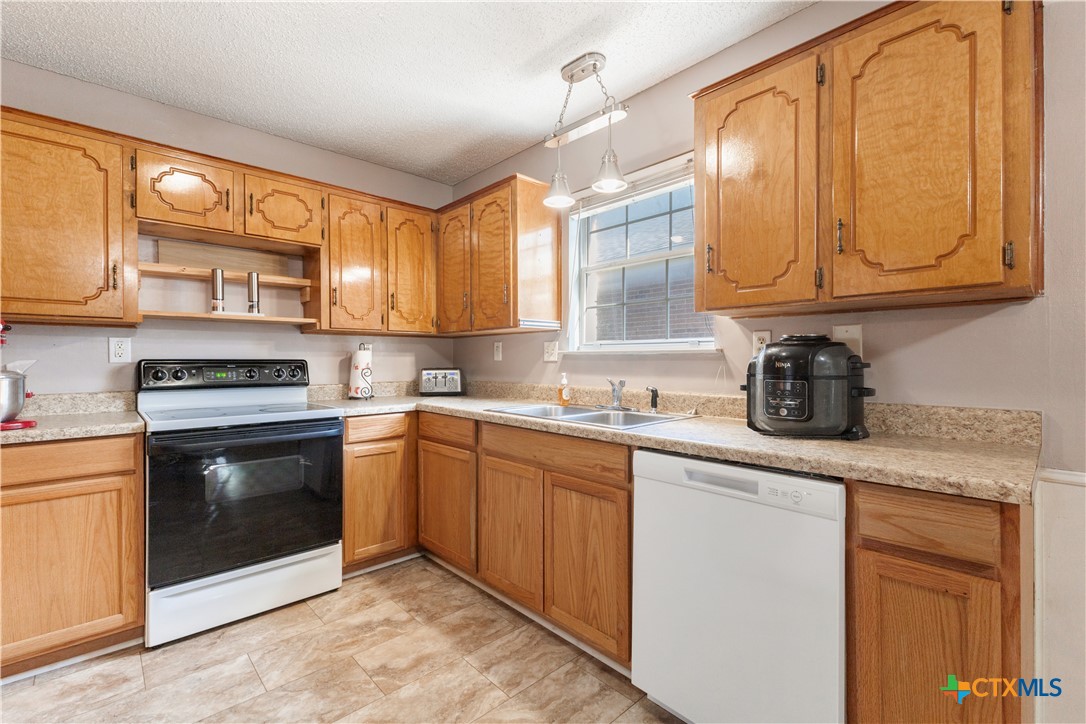 144 Jordan Loop Nolanville, TX 76559 - Photo 12 of 20 a kitchen with granite countertop a sink stainless steel appliances and cabinets