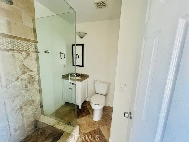 a bathroom with a toilet and a shower