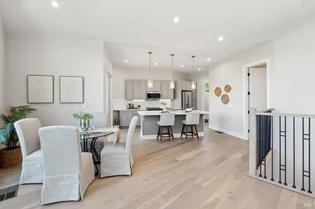 a kitchen with stainless steel appliances granite countertop white cabinets a stove a microwave and a window