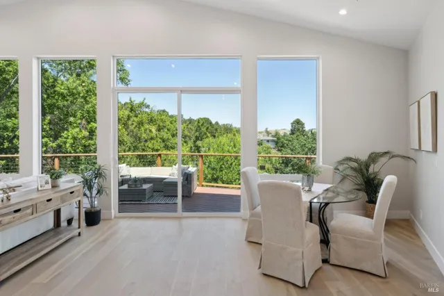 a view of a dining room and livingroom with furniture wooden floor and a rug