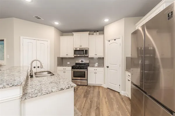 a kitchen with stainless steel appliances granite countertop a refrigerator sink and stove