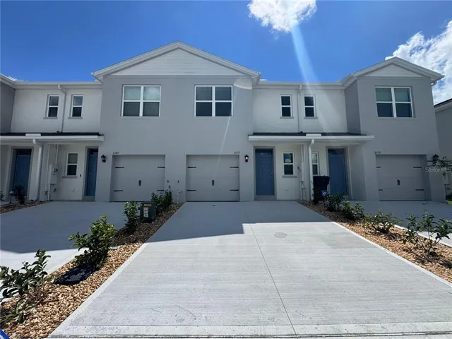 a front view of a house with a yard and a garage