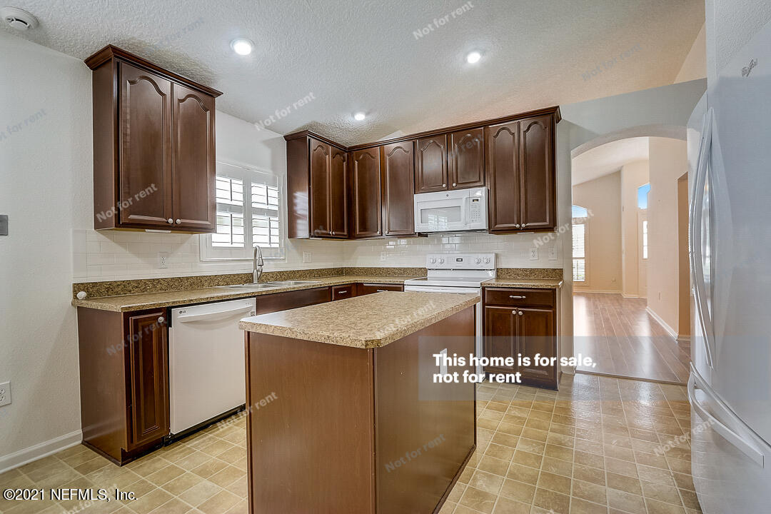 608 Birchbark Trail St. Augustine, FL 32092 - Photo 18 of 35 a kitchen with stainless steel appliances granite countertop a stove a sink a microwave and a refrigerator
