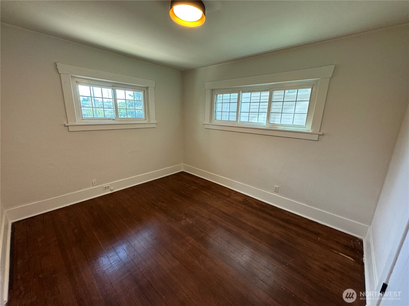 811 Northeast 66th Street Seattle, WA 98115 - Photo 12 of 36 a view of an empty room with wooden floor and a window