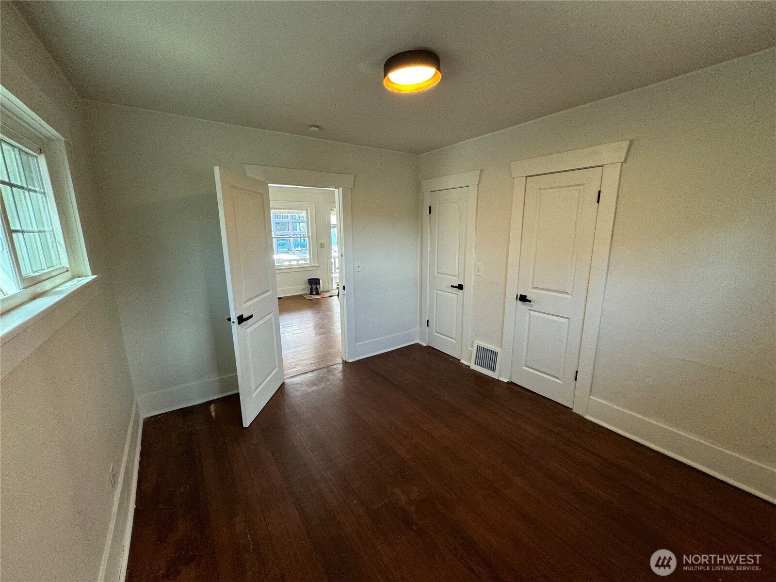811 Northeast 66th Street Seattle, WA 98115 - Photo 13 of 36 an empty room with wooden floor and windows