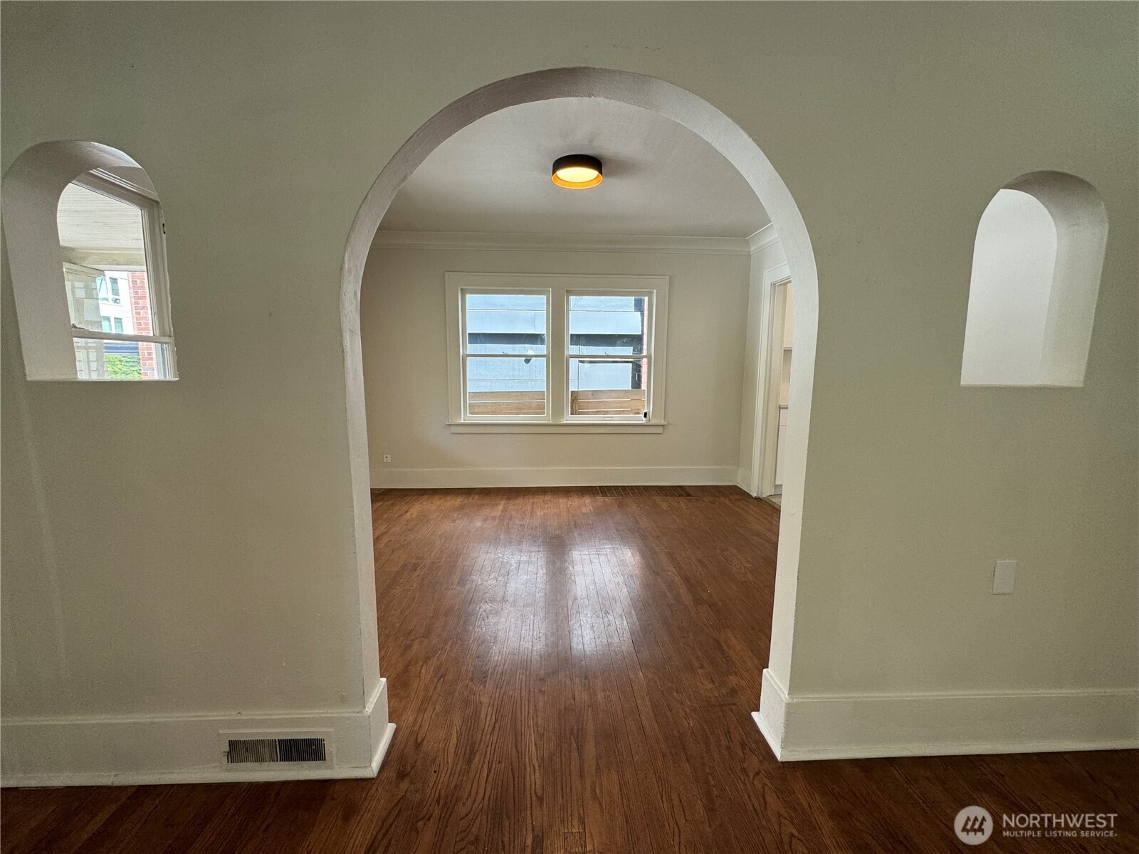 811 Northeast 66th Street Seattle, WA 98115 - Photo 6 of 36 an empty room with wooden floor and windows