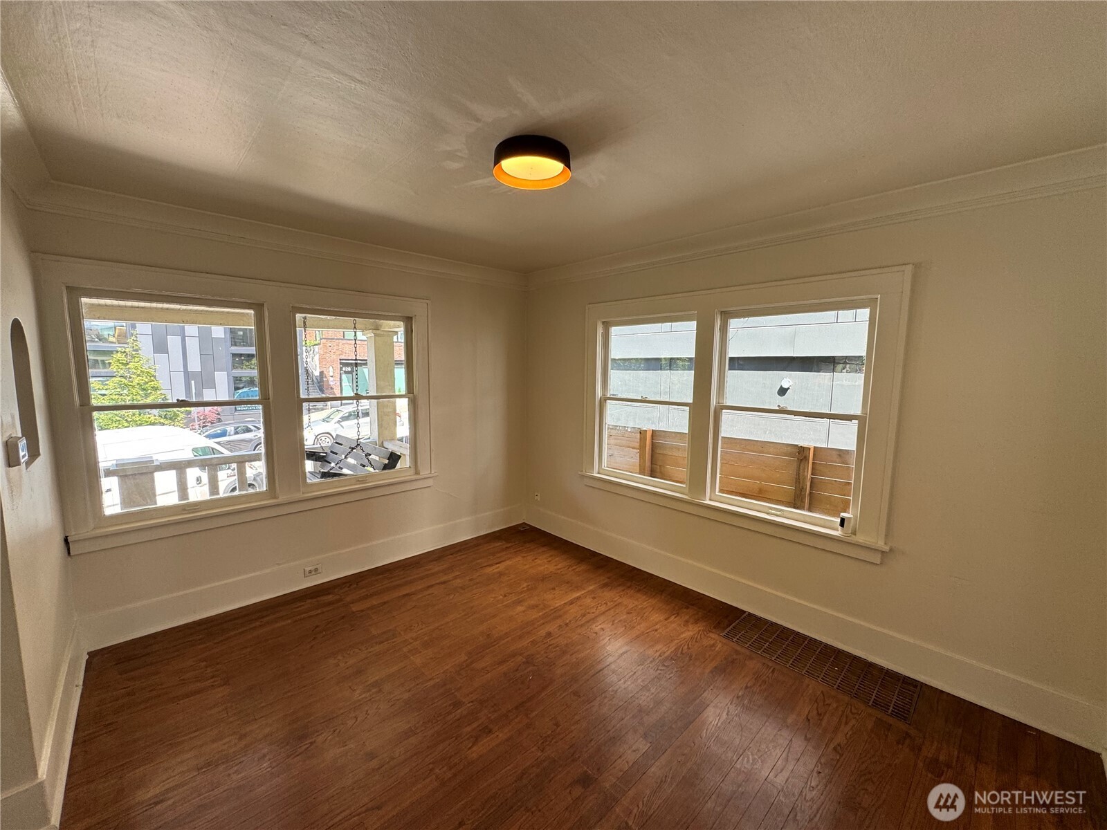 811 Northeast 66th Street Seattle, WA 98115 - Photo 7 of 36 an empty room with wooden floor and windows