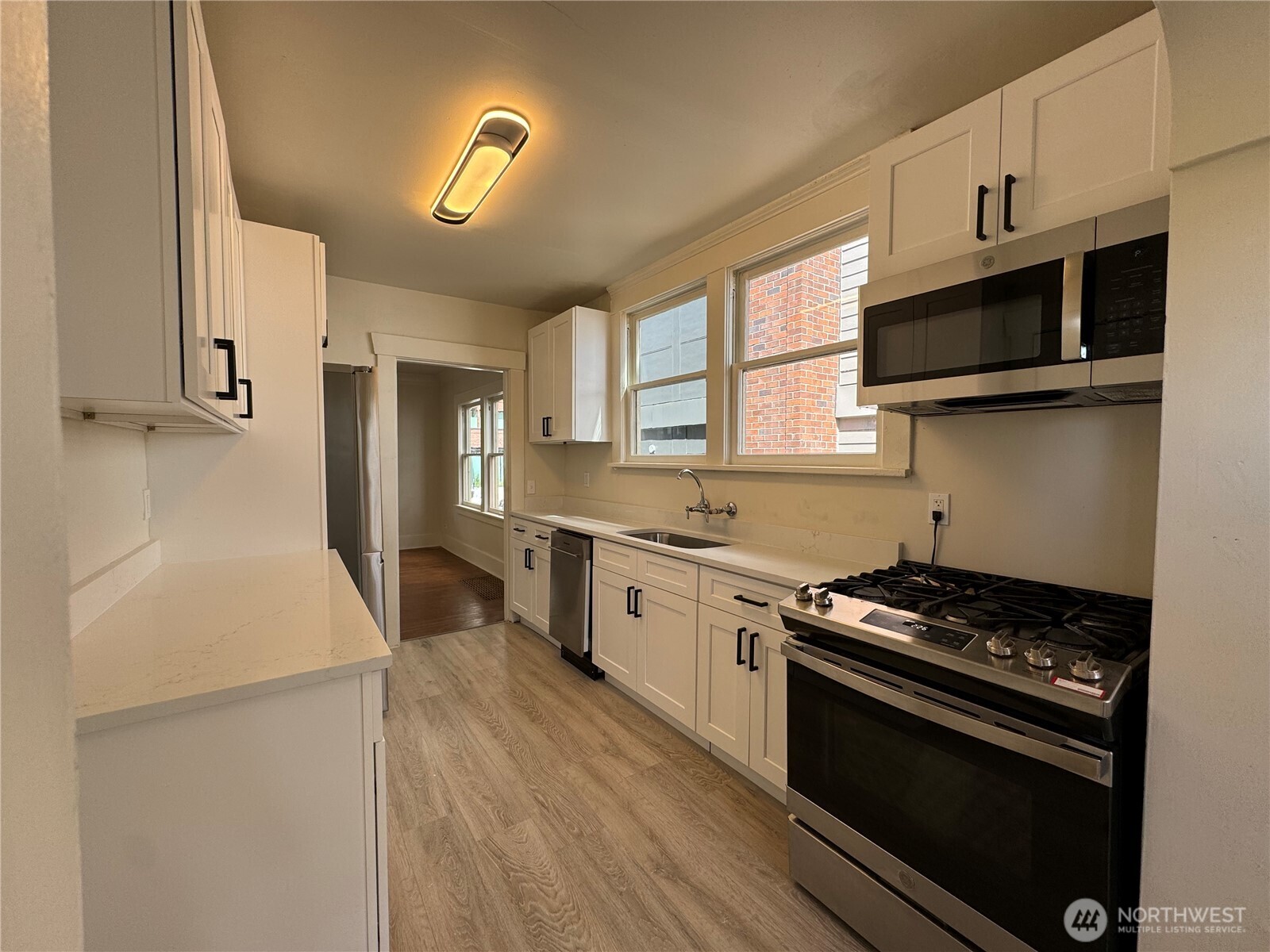 811 Northeast 66th Street Seattle, WA 98115 - Photo 9 of 36 a kitchen with stainless steel appliances a stove microwave and sink