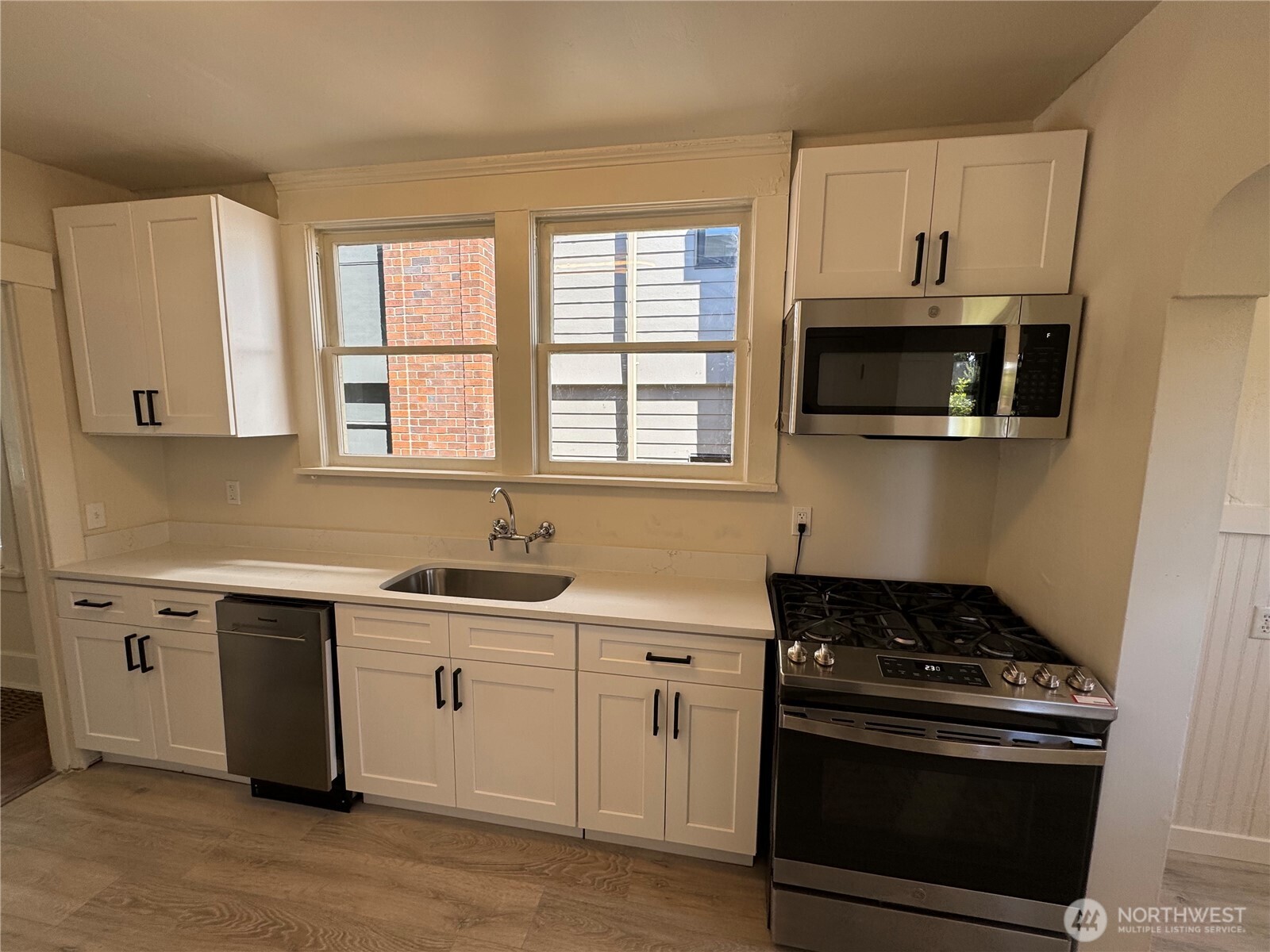 811 Northeast 66th Street Seattle, WA 98115 - Photo 10 of 36 a kitchen with stainless steel appliances a stove a sink and a microwave