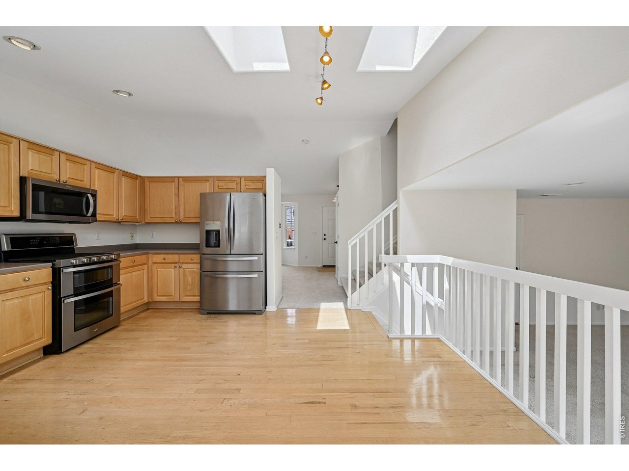 a kitchen with stainless steel appliances granite countertop a refrigerator a stove a sink dishwasher a microwave oven with cabinets and wooden floor