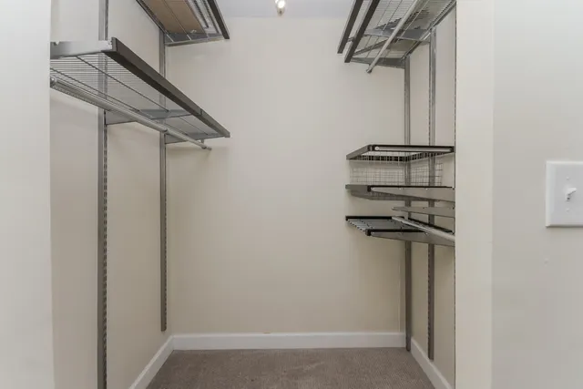 a view of walk in closet with empty racks
