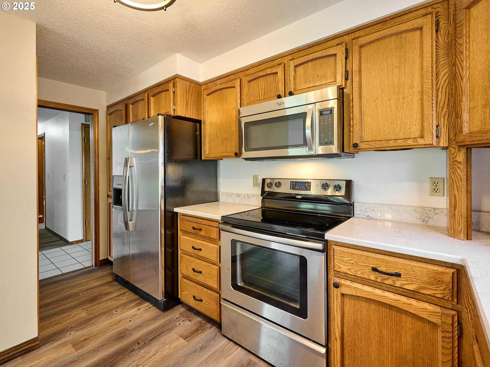 2135 Country Club Terrace Woodburn, OR 97071 - Photo 11 of 36 a kitchen with stainless steel appliances granite countertop a stove a microwave and a refrigerator