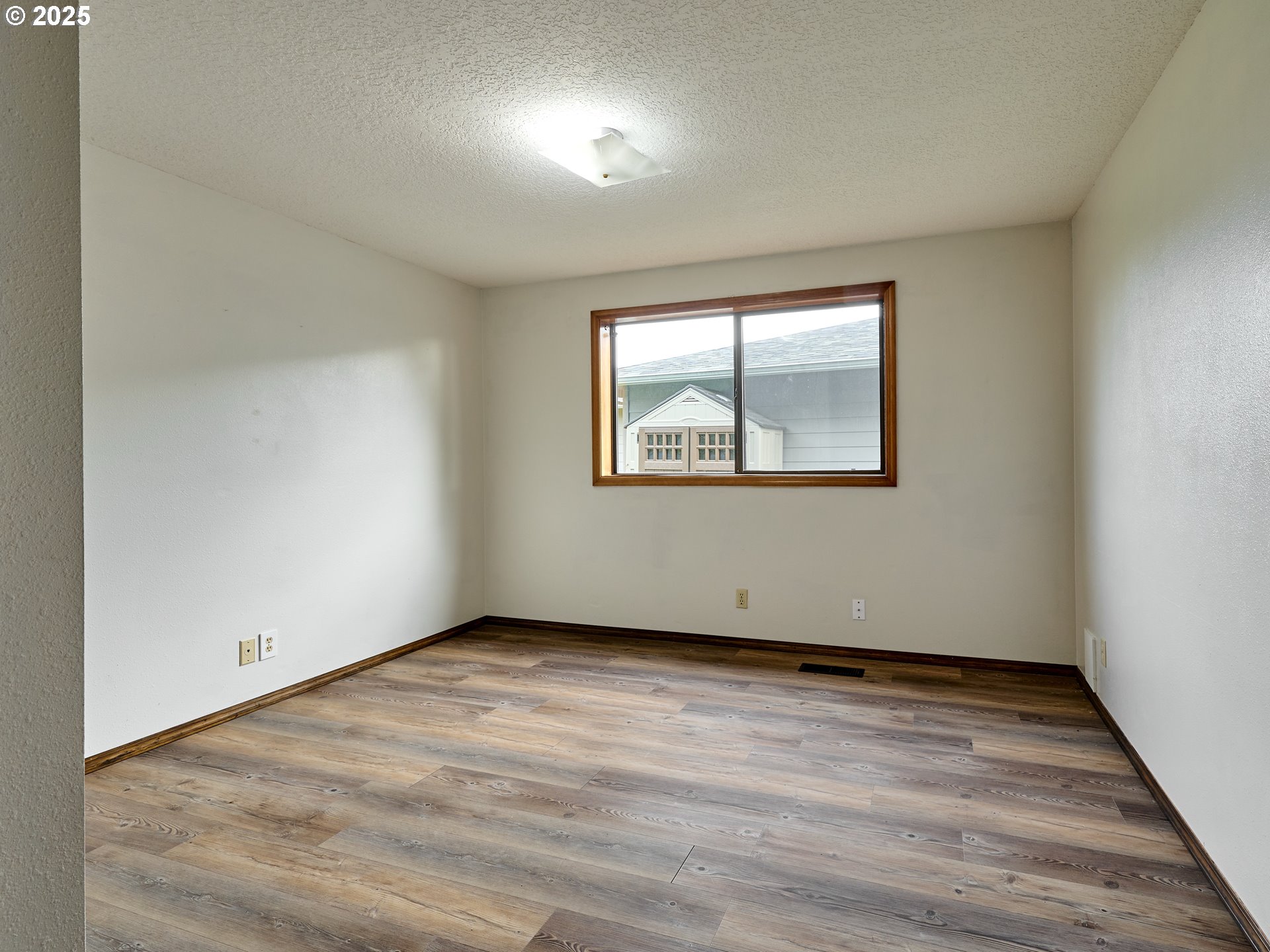 2135 Country Club Terrace Woodburn, OR 97071 - Photo 15 of 36 an empty room with wooden floor and windows