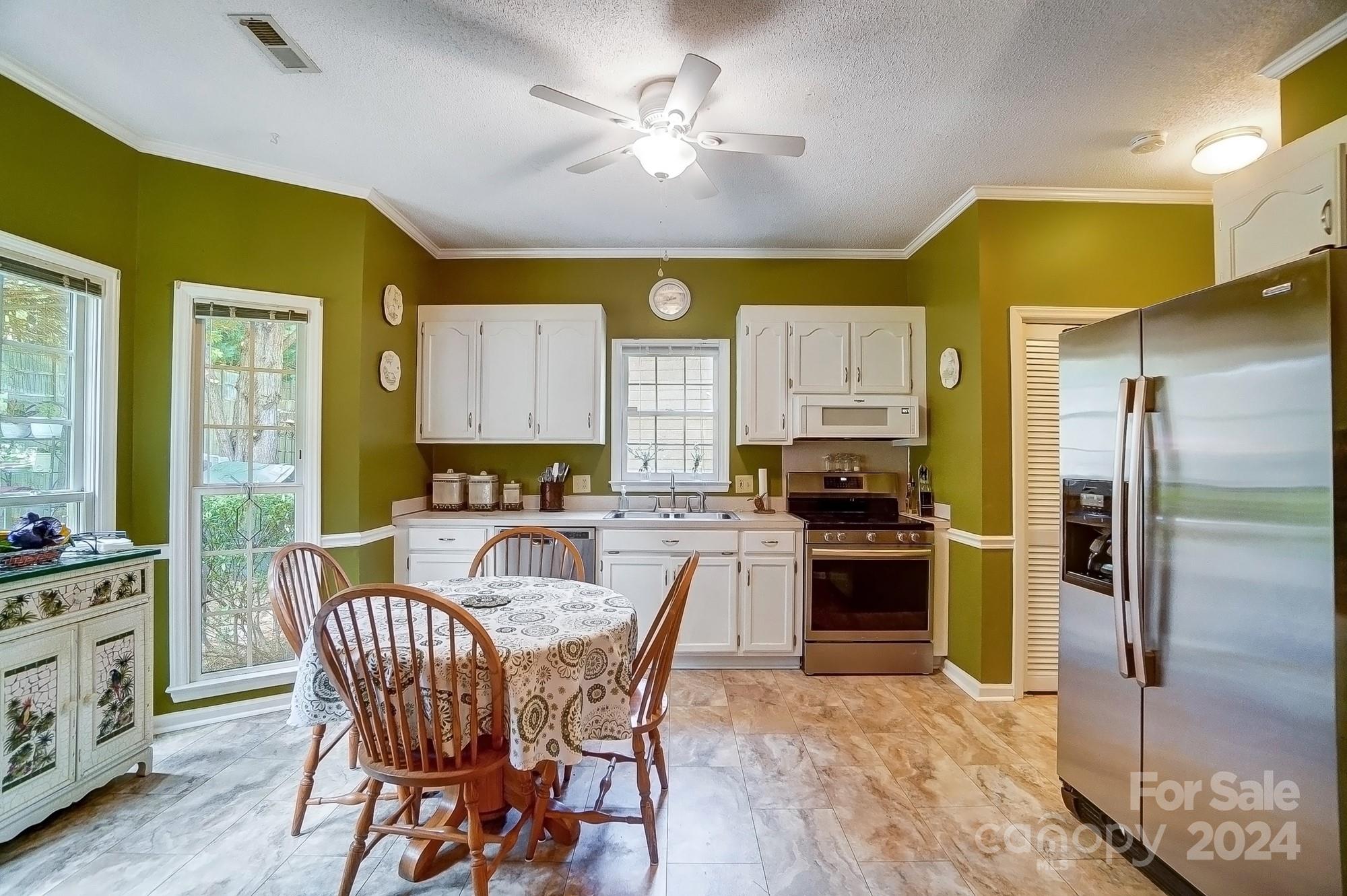 3063 River Ridge Drive Gastonia, NC 28056 - Photo 11 of 42 a kitchen with a refrigerator a stove a sink dishwasher with a dining table and chairs