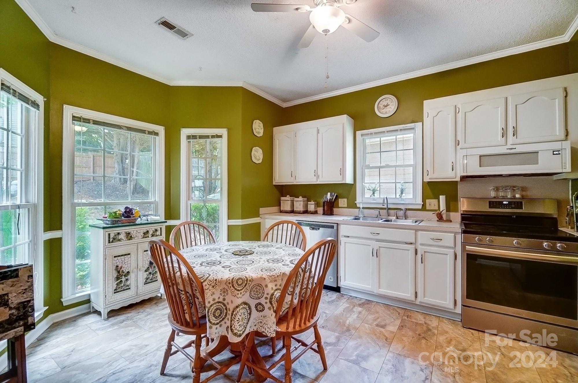 3063 River Ridge Drive Gastonia, NC 28056 - Photo 12 of 42 a kitchen with a table chairs sink and cabinets