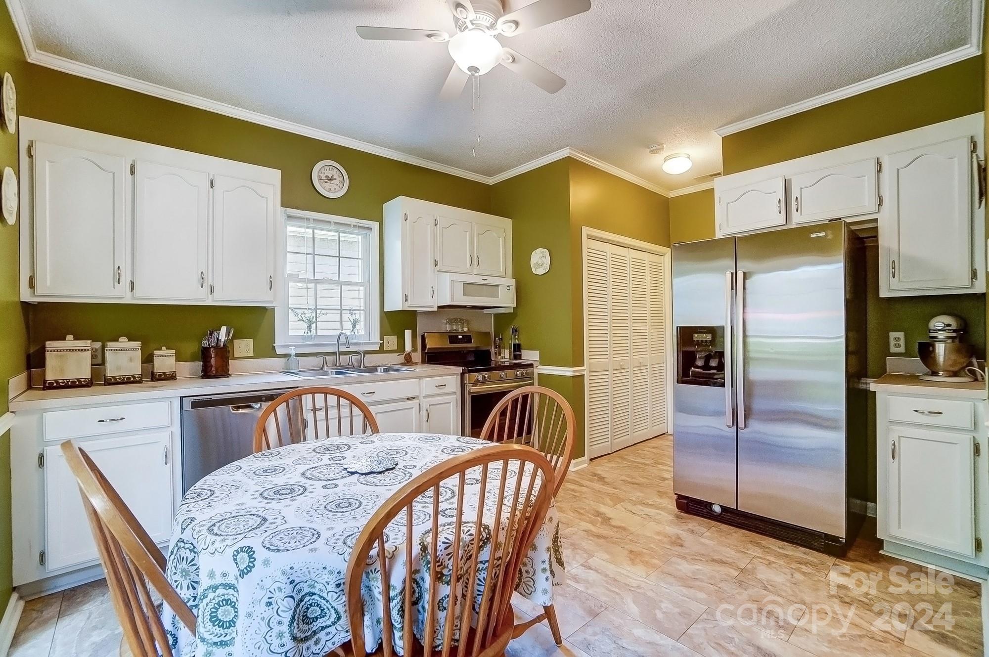 3063 River Ridge Drive Gastonia, NC 28056 - Photo 13 of 42 a kitchen with stainless steel appliances granite countertop a sink a stove a refrigerator with a dining table and chairs