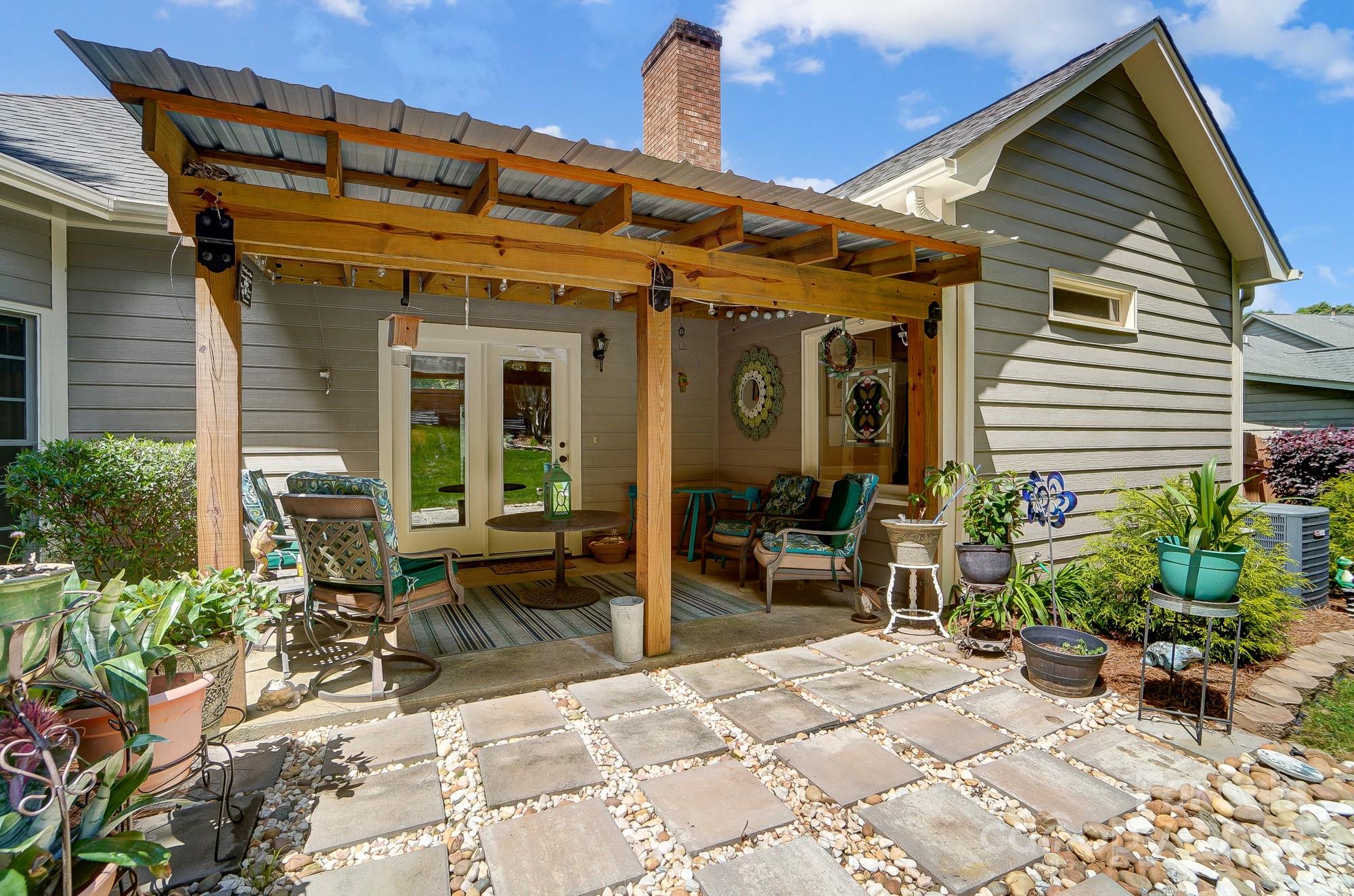 3063 River Ridge Drive Gastonia, NC 28056 - Photo 36 of 42 a view of a patio with table and chairs potted plants and floor to ceiling window