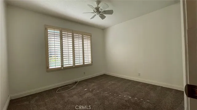 an empty room with a window and a fan