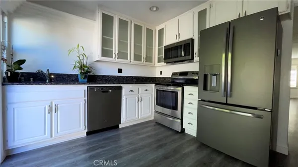 a kitchen with stainless steel appliances a refrigerator sink and microwave