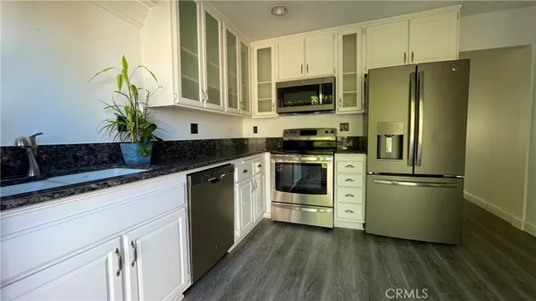 a kitchen with stainless steel appliances a refrigerator sink and microwave
