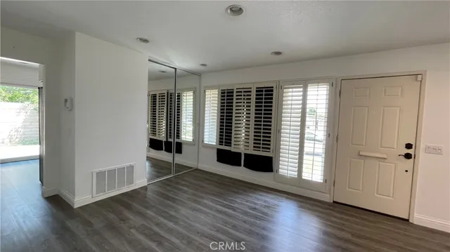 an empty room with wooden floor and windows