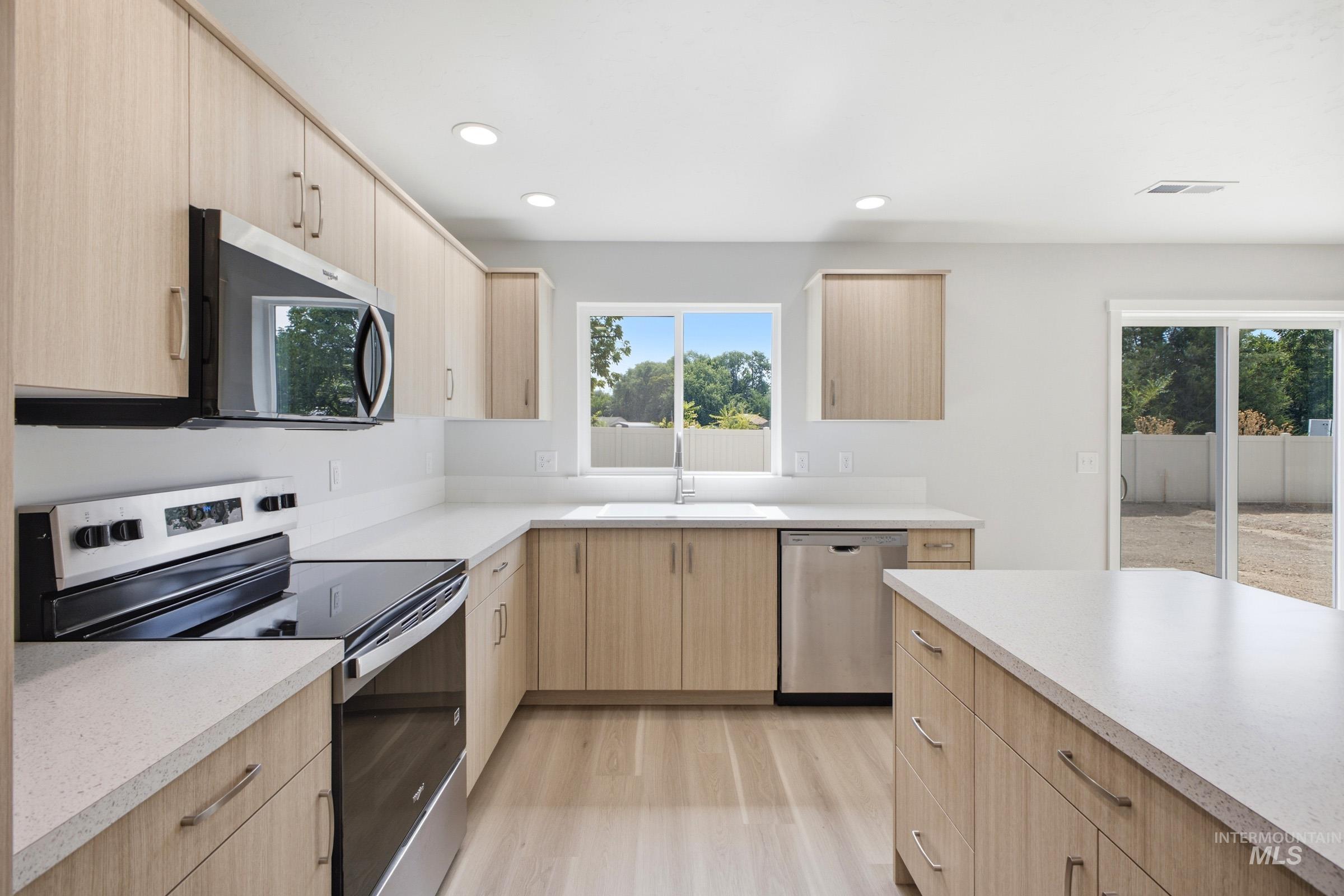 13336 Bank Street Caldwell, ID 83607 - Photo 10 of 24 Modern kitchen featuring light wood-finish cabinetry, stainless steel appliances, white countertops, and recessed lighting