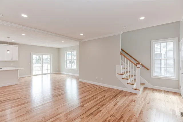 a view of a hallway with wooden floor and windows