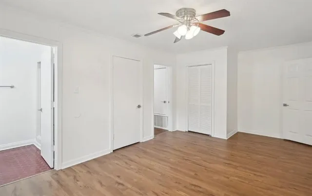 a view of a big room with wooden floor and a chandelier fan