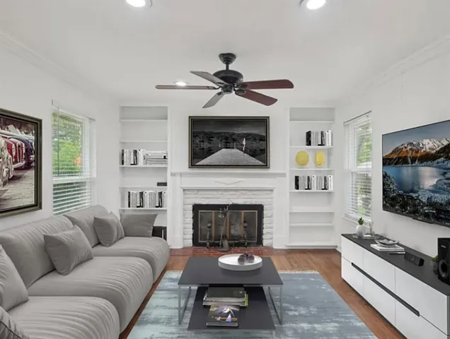 a living room with furniture a flat screen tv and a fireplace