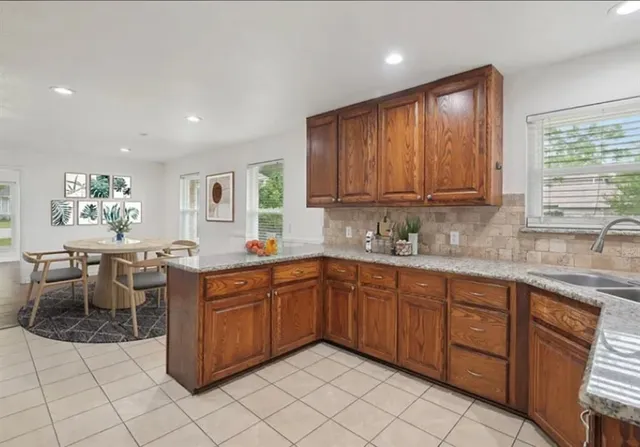 a kitchen with a sink window and cabinets