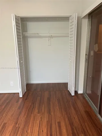 an empty room with wooden floor and a window