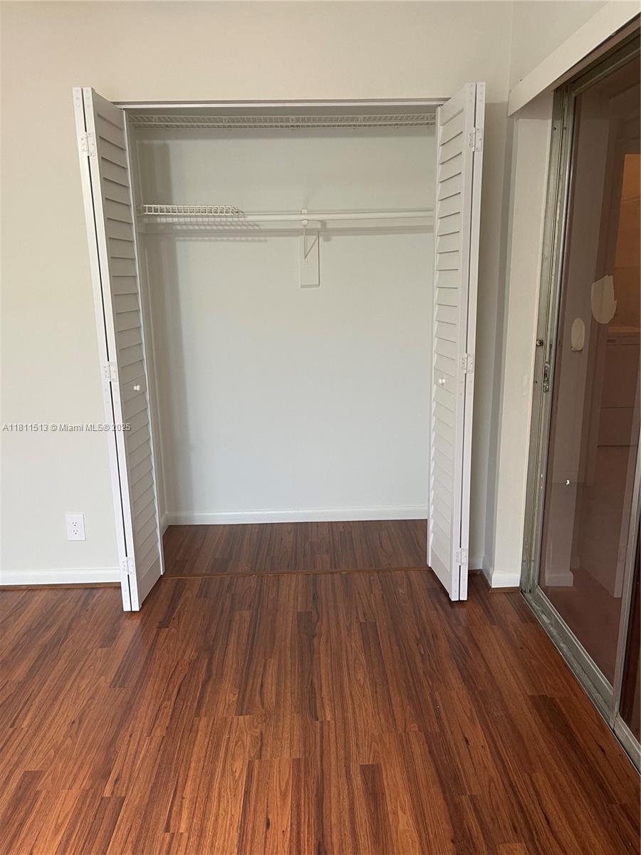 413 Saxony Way, Unit 413 Delray Beach, FL 33446 - Photo 5 of 14 an empty room with wooden floor and a window