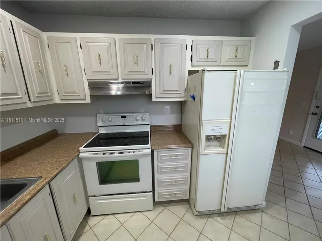 a kitchen with white cabinets and white appliances